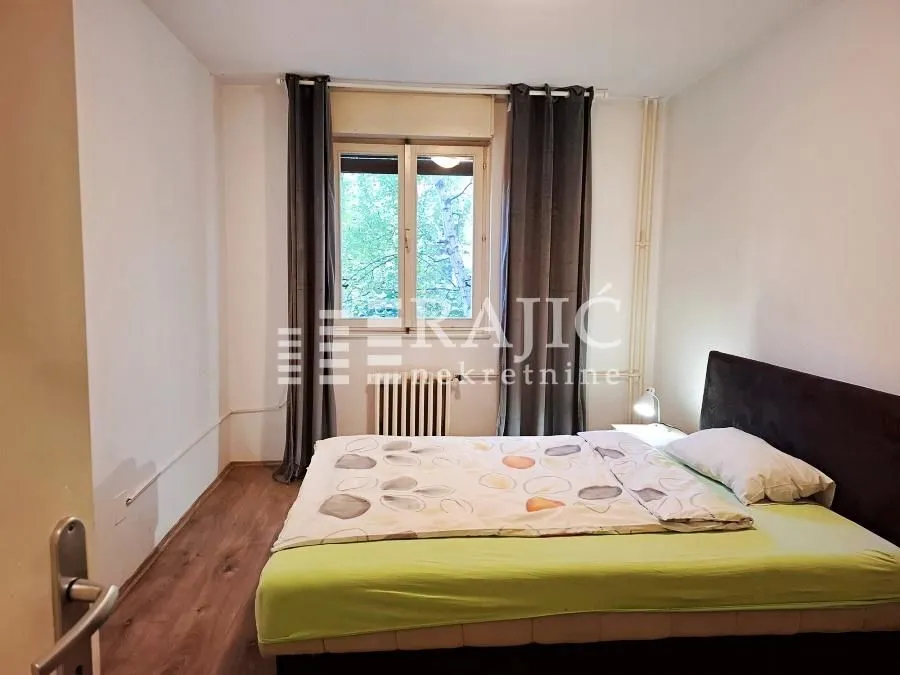 Furnished bedroom with a double bed and a window.