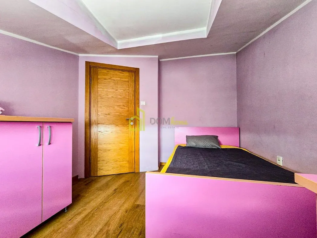 Dječija soba sa krevetom i roze namještajem.