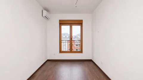 Empty room with wooden flooring, white walls, and a window. - image 8