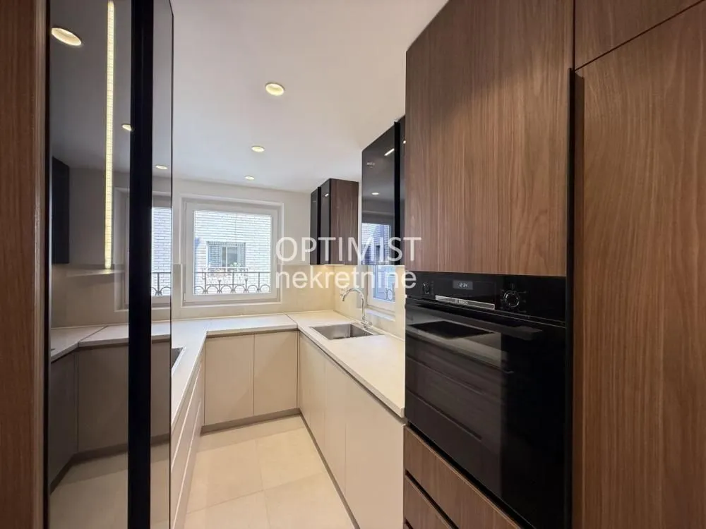 Modern kitchen with wooden cabinets and a built-in oven.
