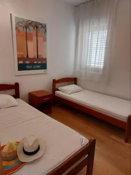 Spavaća soba sa dva singl kreveta i noćnim ormarićem. - image 17