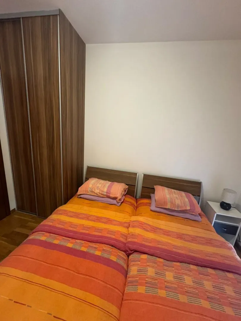 Spavaća soba sa bračnim krevetom i ugradnim ormarom.