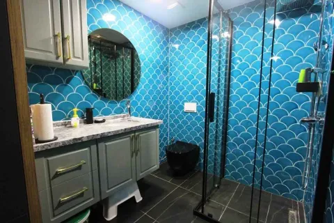 Modern bathroom with a shower cabin and blue tiles. - image 4