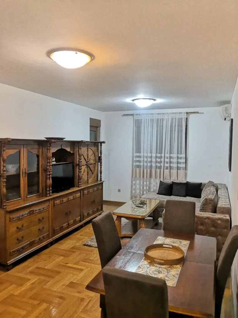 Dnevna soba sa trpezarijom i drvenim namještajem.