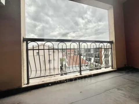 Natkriveni balkon sa metalnom ogradom i pogledom na naselje. - image 11