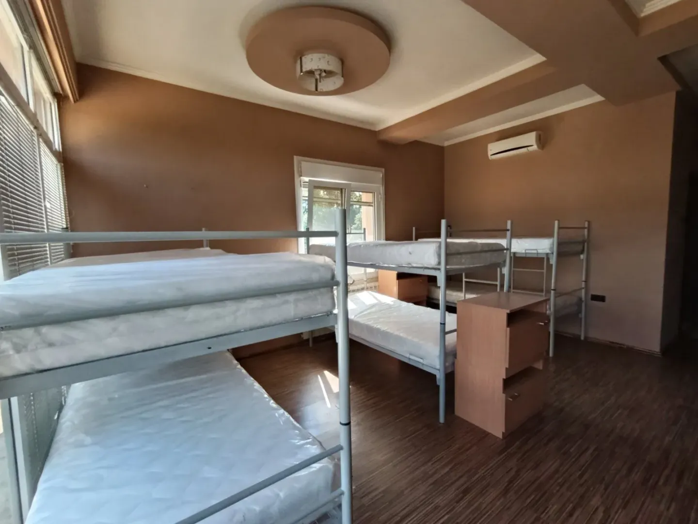 Bedroom with multiple bunk beds and bedside tables.