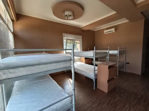 Bedroom with multiple bunk beds and bedside tables. - image 7