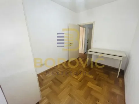 Empty room with parquet flooring and a desk. - image 4