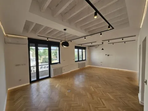 Spacious empty room with wooden parquet flooring, white walls, and modern lighting. - image 11