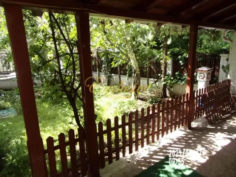 Natkrivena terasa sa drvenom ogradom i pogledom na zeleno dvorište. - image 19