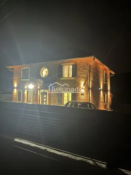 Noćni pogled na spoljašnjost kuće sa fasadom od cigle i osvetljenjem. - image 5
