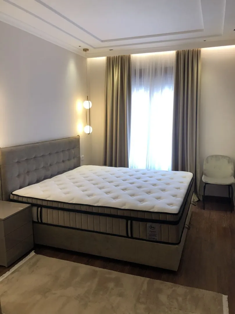 Bright bedroom with a large double bed and modern lighting.