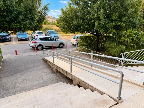 View of the building entrance with stairs and an access ramp. - image 9