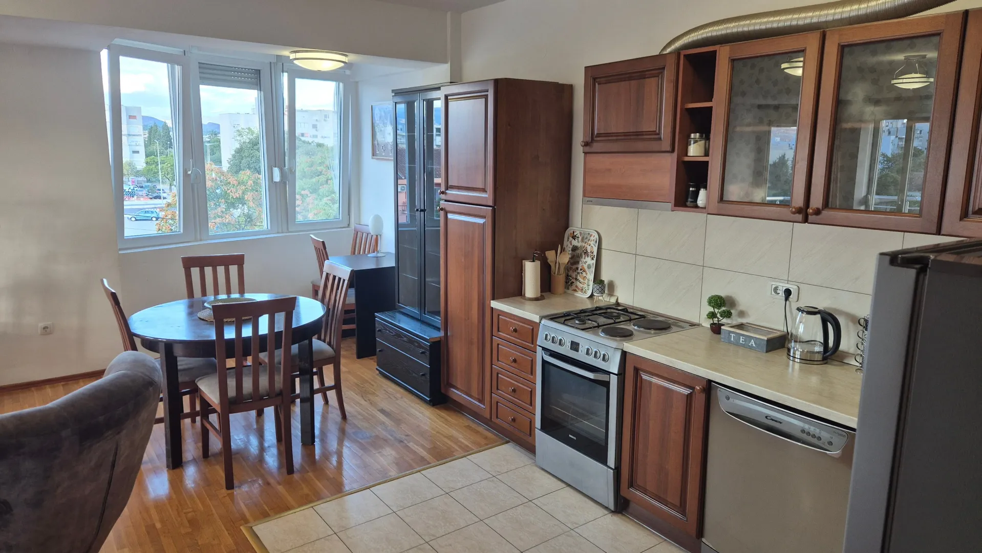 Kitchen with wooden cabinetry and a dining area in an open-plan space.