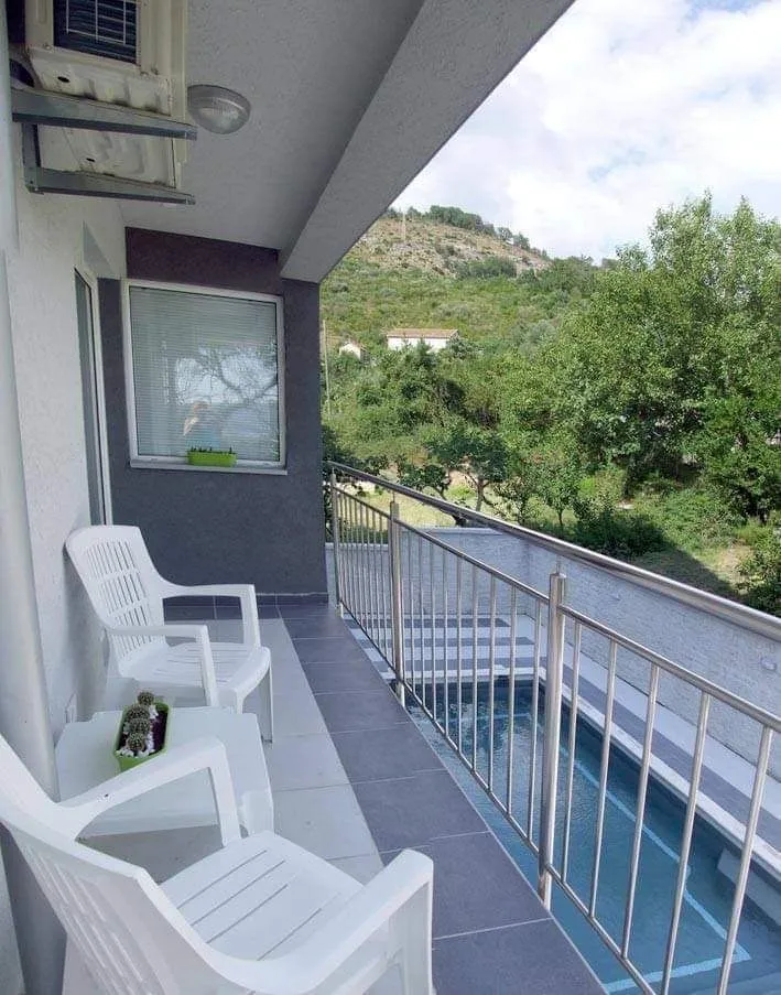 Covered view from the balcony overlooking the pool and green surroundings.