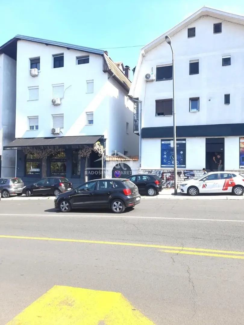 View of the building exterior with the street and parked cars.