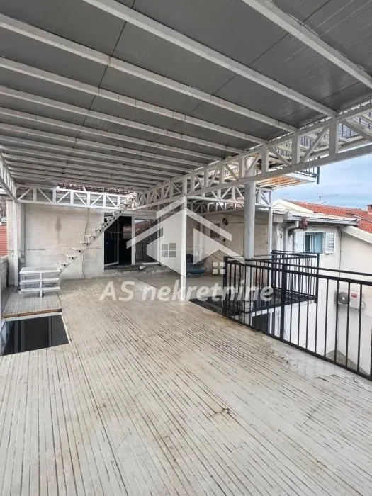 Large covered terrace with a metal structure and stairs.