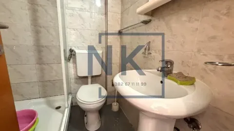 Smaller bathroom with a shower cabin, washbasin, and toilet. - image 11
