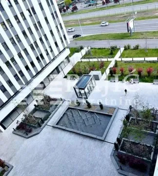 High-angle view of the landscaped courtyard in front of the building with greenery. - image 3