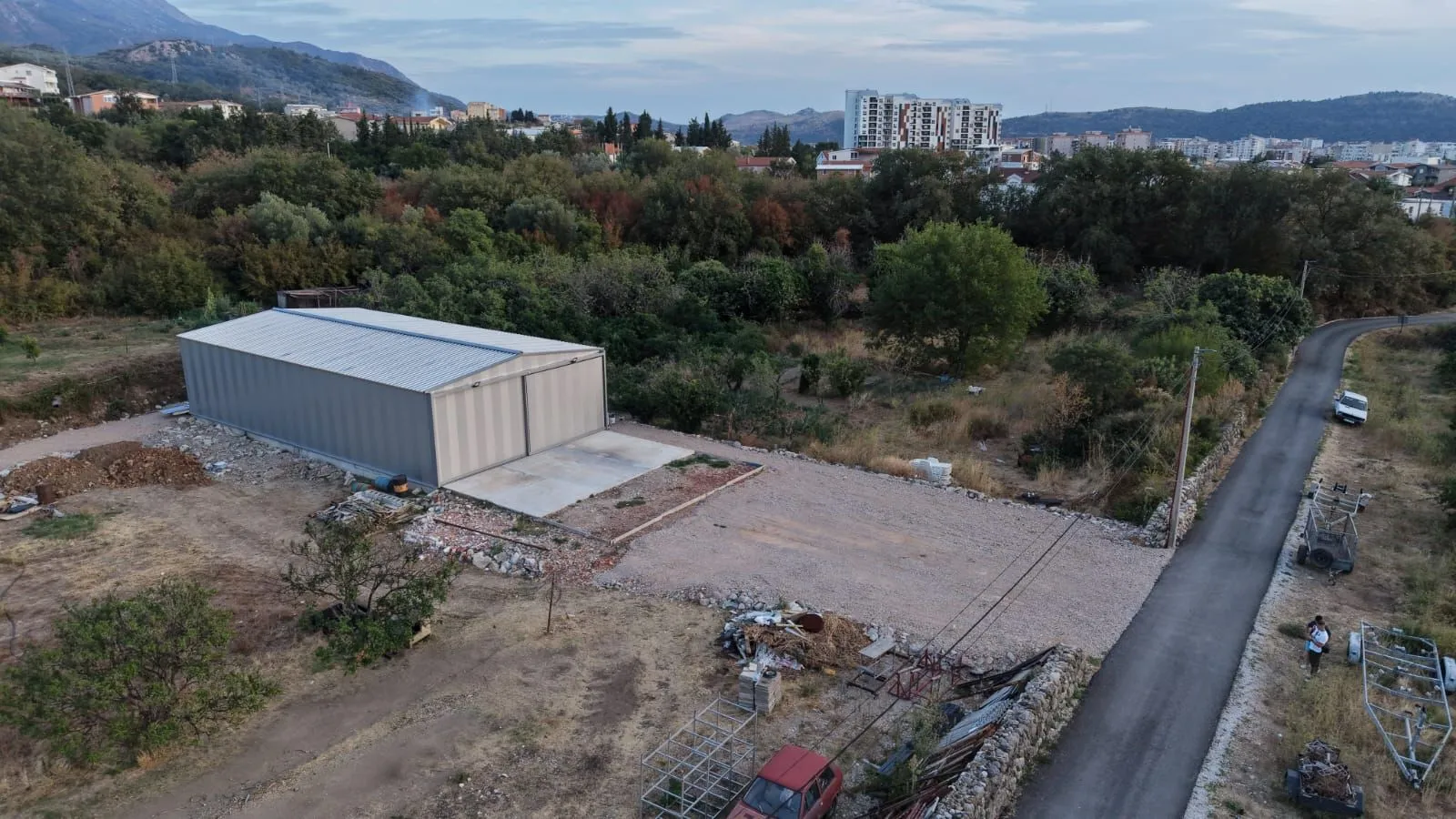 Aerial view of the warehouse and surrounding land with a road.