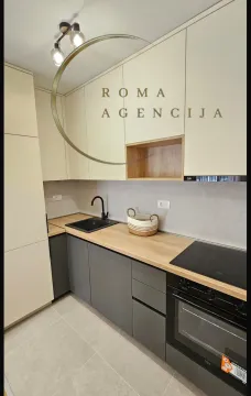 Moderna kuhinja sa drvenom radnom površinom i tamnim elementima. - image 4