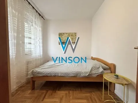 Manja spavaća soba sa drvenim krevetom i prozorom prekrivenim zavesama. - image 8