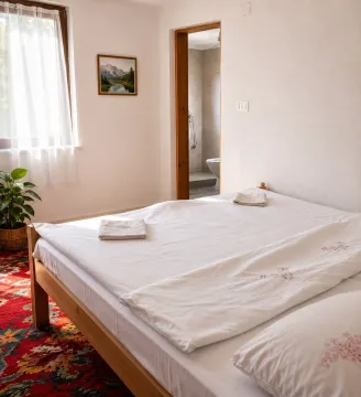 Bright bedroom with a large double bed and a view of the bathroom. - image 4