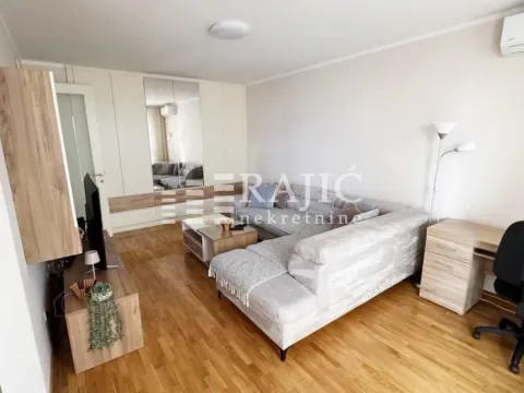 Living room with a sofa, TV, and desk. - image 2