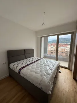 Furnished bedroom with a double bed and city view. - image 10
