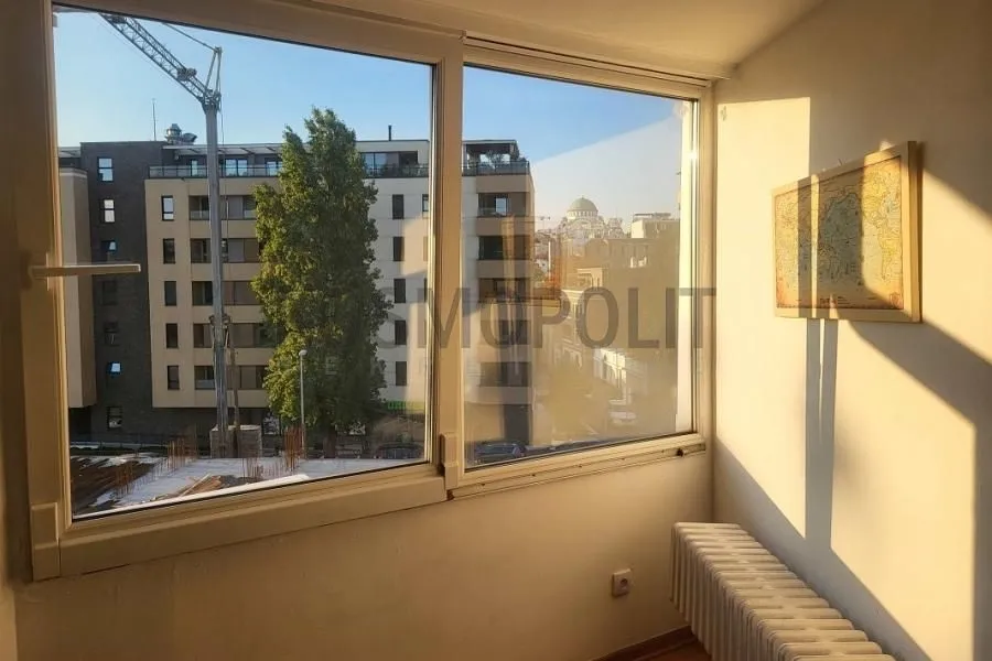 Pogled kroz veliki prozor na okolne zgrade i gradski pejzaž.