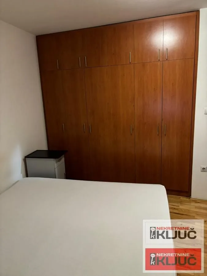 Spavaća soba sa velikim ugradnim garderoberom i bračnim krevetom.