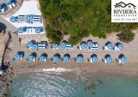 Pogled iz vazduha na uređenu plažu sa suncobranima i ležaljkama pored mora. - image 11