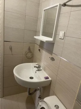 Jednostavno kupatilo sa bijelim umivaonikom i ogledalom. - image 9