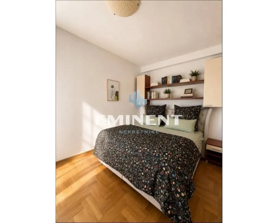 Furnished bedroom with a double bed and wall shelves.