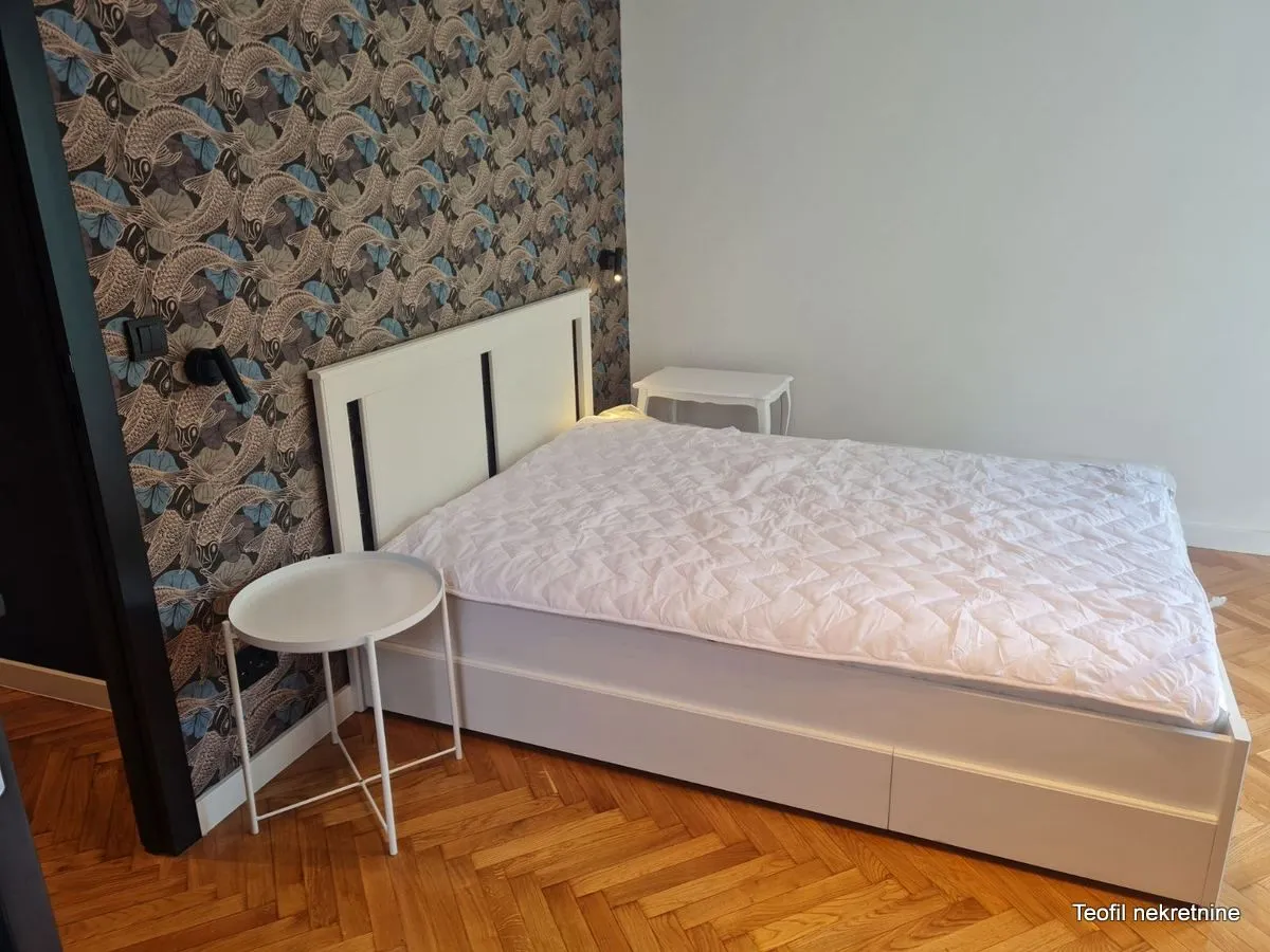 Bedroom with a double bed and patterned wallpaper.