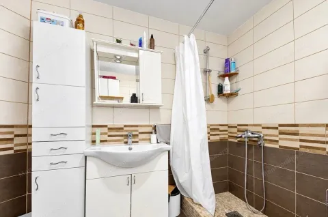 Compact bathroom with a sink, white cabinet, and shower area. - image 3