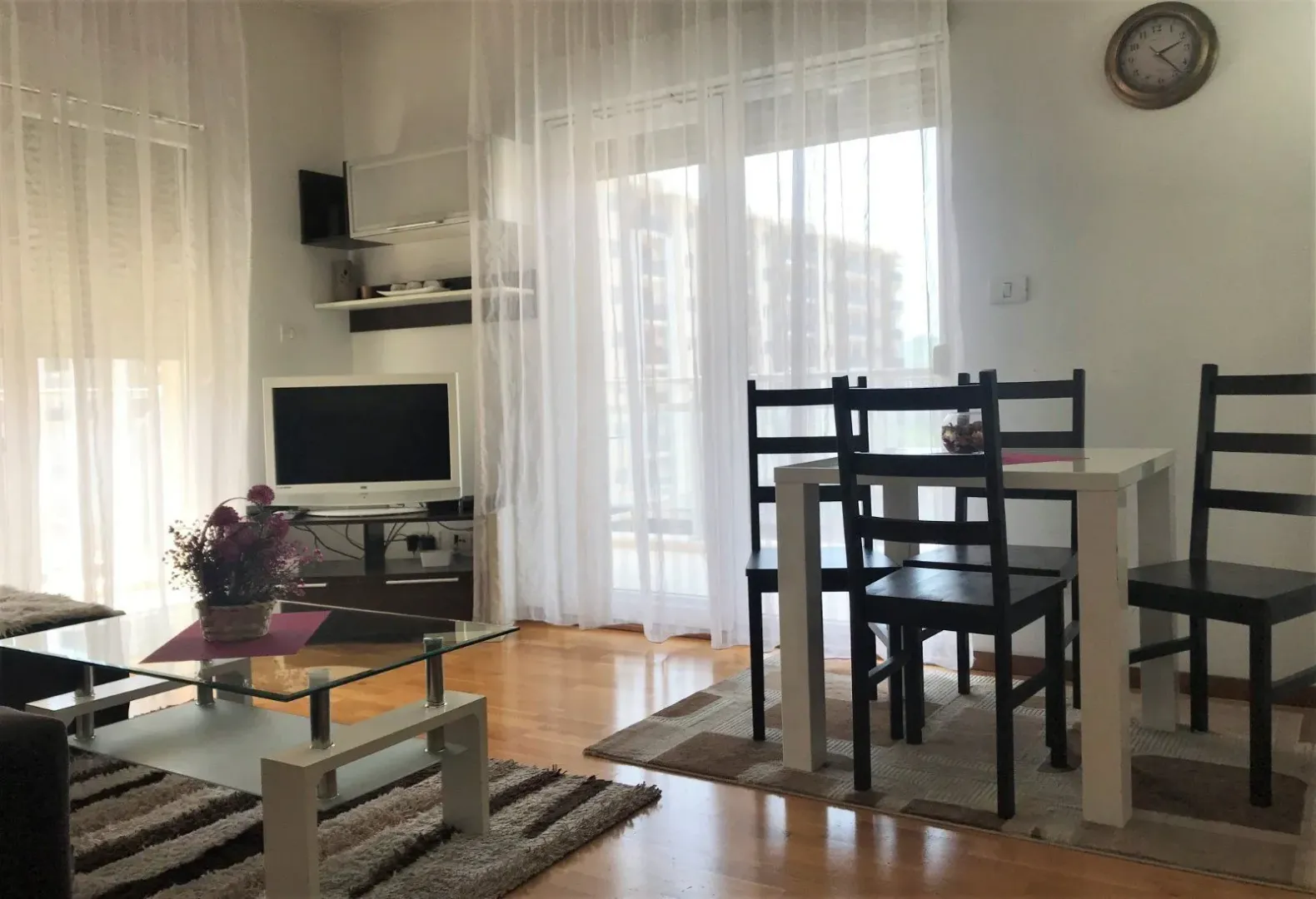 Svijetla dnevna soba sa trpezarijskim stolom i izlazom na terasu.
