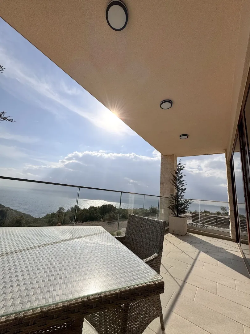 Covered terrace with outdoor seating and a sea view.