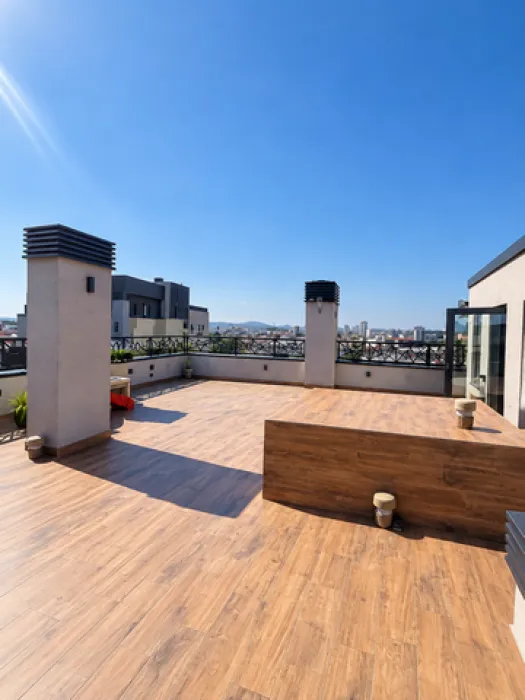 Large spacious terrace with wooden flooring and city views.