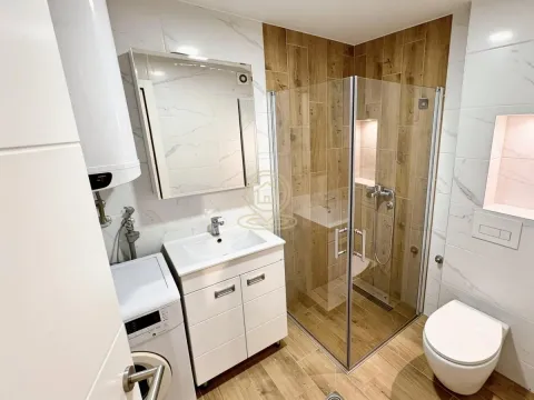 Savremeno opremljeno kupatilo sa tuš kabinom, umivaonikom i veš mašinom. - image 7