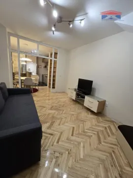 Dnevna soba sa garniturom, TV-om i pogledom na trpezariju. - image 5