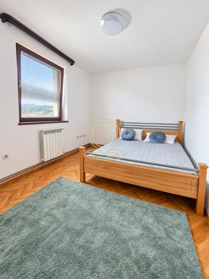 Bedroom with a wooden bed and a window.