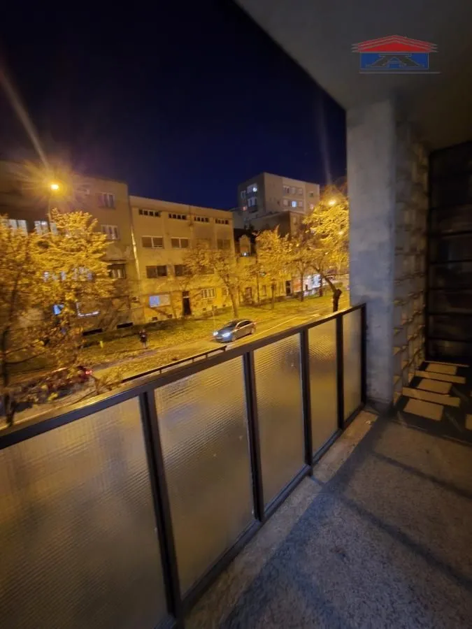 View from the balcony of the illuminated street and buildings at night.