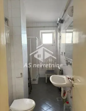 Smaller bathroom with a shower cabin, sink, and toilet. - image 13