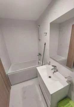 Manje kupatilo sa bijelim pločicama, kadom i umivaonikom sa ormarićem. - image 11