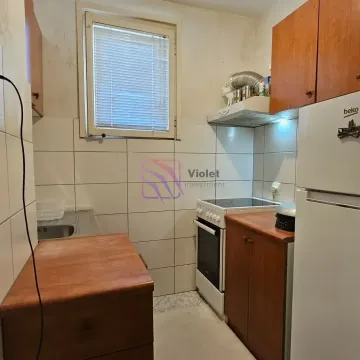 Manja kuhinja sa drvenim elementima, šporetom i frižiderom. - image 8