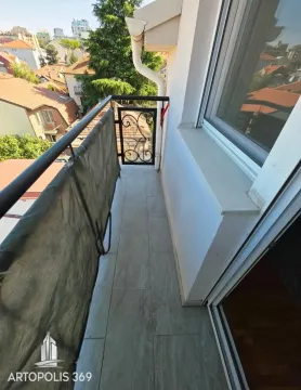 Narrow balcony with tiled floor and a railing with a protective net. - image 19