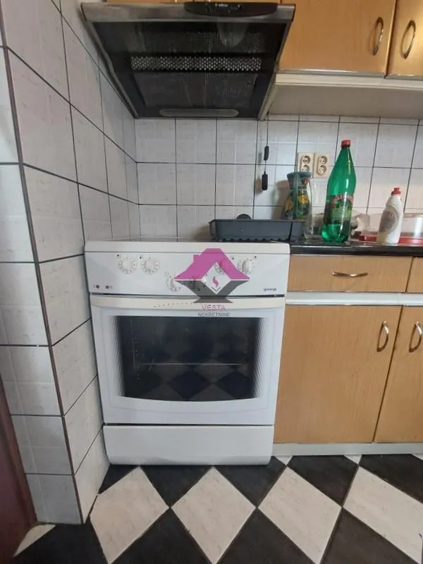 Manja kuhinja sa štednjakom i drvenim elementima.