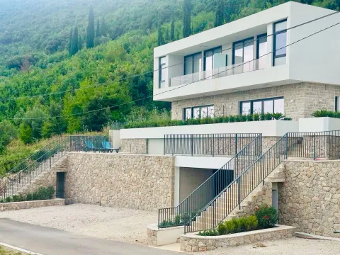 Moderna dvospratna vila sa kamenim zidovima i terasom okružena zelenilom. - image 2