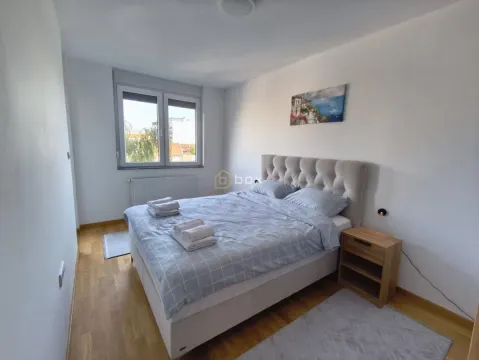 Spavaća soba sa bračnim krevetom, noćnim stočićem i prozorom. - image 6
